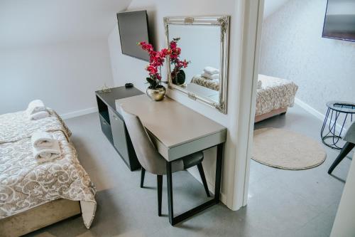a bedroom with a desk with a mirror and a bed at Vazdušna Banja in Niš