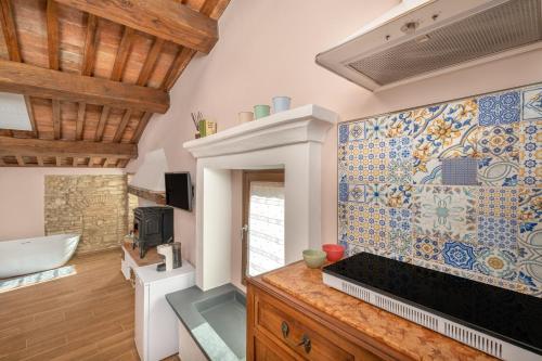 a bathroom with a mosaic tile wall with a tub at Casa Serena in Vicopisano