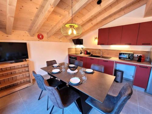 une cuisine avec une table et des chaises et une télévision dans l'établissement Appartement lumineux avec balcon, proche pistes et parking sécurisé - Les Gets - FR-1-598-162, aux Gets