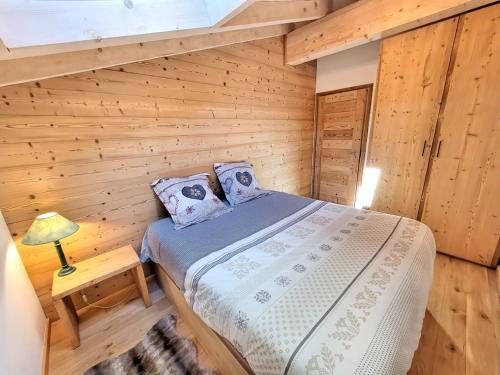 une chambre avec un lit dans une cabane en bois dans l'établissement Appartement lumineux avec balcon, proche pistes et parking sécurisé - Les Gets - FR-1-598-162, aux Gets