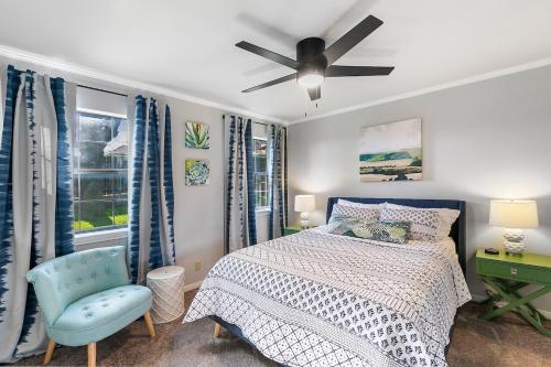 ein Schlafzimmer mit einem Bett und einem Deckenventilator in der Unterkunft Das Bach Haus - Game Room Make-Up Room & Hot Tub in Fredericksburg