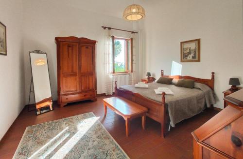 a bedroom with a bed and a table in it at Agriturismo Le Case di San Vivaldo in Montaione