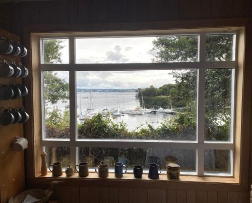 a window with a view of a boat in the water at Cabaña en tu propia Isla in Chonchi