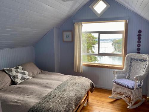 a bedroom with a bed and a window and a chair at Cabaña en tu propia Isla in Chonchi