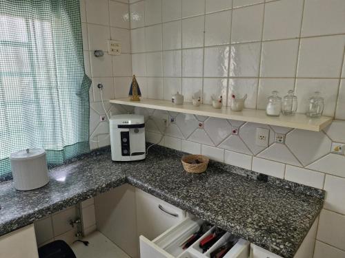 a small kitchen with a counter and a counter top at Chacara espetacular em condomínio fechado in Ribeirão Preto
