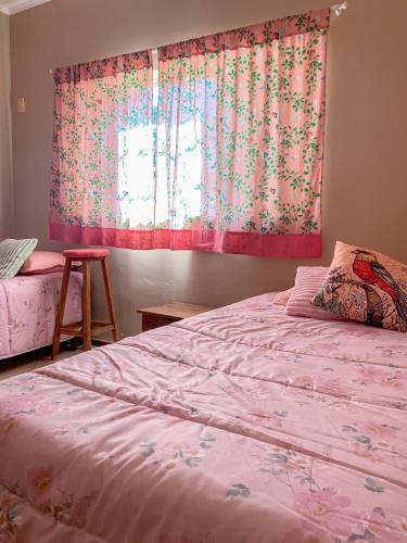 a bedroom with a pink bed and a window at Chacara espetacular em condomínio fechado in Ribeirão Preto