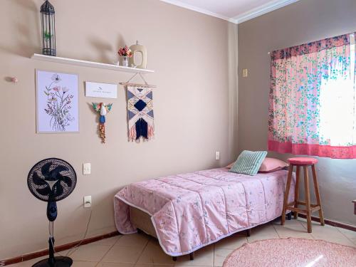 a bedroom with a pink bed and a window at Chacara espetacular em condomínio fechado in Ribeirão Preto