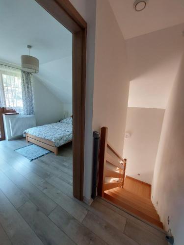 a room with a bedroom with a bed and a doorway at Domek na Leśnej Wisła in Wisła