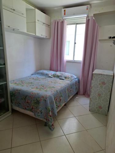 a small bedroom with a bed and a window at Ilhéus Temporada in Ilhéus