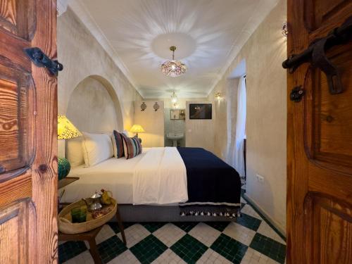 a bedroom with a bed and a chandelier at Riad Alena in Marrakesh
