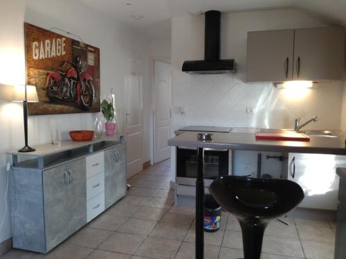 - une cuisine avec un comptoir, un évier et une table dans l'établissement Maison de biscuit, à Ugine