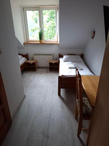 a small room with a bed and a window at Zajazd Gajówka in Zwierzyniec