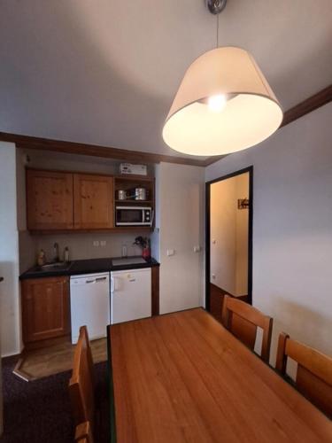 d'une cuisine lumineuse avec une table à manger. dans l'établissement Résidence La Marelle et Le Rami - maeva Home - Appartement au pied des pistes 3 pièces 7 personnes - Sélection - super Home MAE-3881, à La Plagne Tarentaise