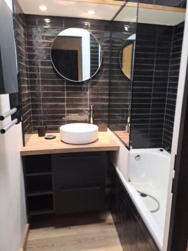 une salle de bain avec un lavabo et un miroir dans l'établissement Résidence La Marelle et Le Rami - maeva Home - Appartement au pied des pistes 3 pièces 7 personnes - Sélection - super Home MAE-3881, à La Plagne Tarentaise
