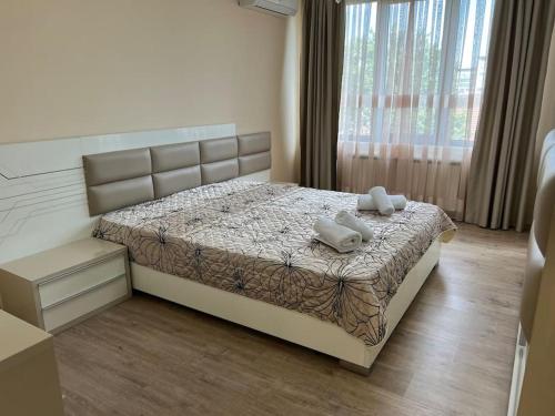 a bedroom with a bed with two towels on it at Cozy apartment - free parking in Plovdiv