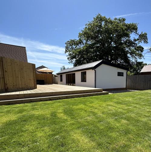 a yard with a white house and a fence at White Oaks Sussex in Twineham
