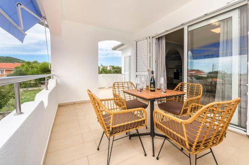 a patio with a table and chairs on a balcony at Apartments Maris in Tribunj