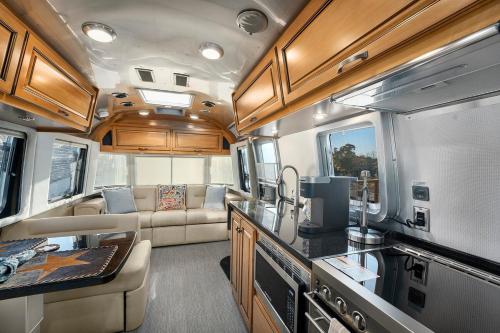 a kitchen and living room of an rv at Airstream Getaway - Hot Tub & Fire Pit in Luckenbach