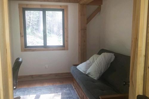 a living room with a couch and a window at The Hollow in Plymouth