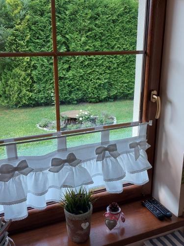a window with white bows on a window sill at Domek na Leśnej Wisła in Wisła