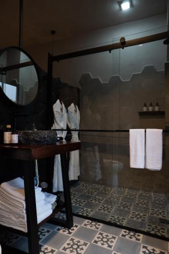 a bathroom with a shower and a table and a mirror at Hotel Piedras Neg in San Miguel de Allende
