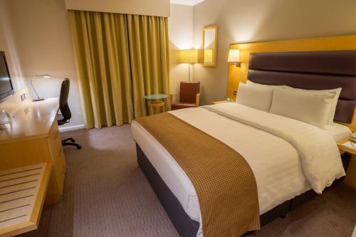 a hotel room with a large bed and a desk at Holiday Inn London Brentford Lock by IHG in Brentford