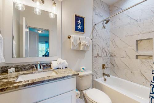 a bathroom with a sink and a toilet and a mirror at Salt & Sand Sanctuary in Orange Beach