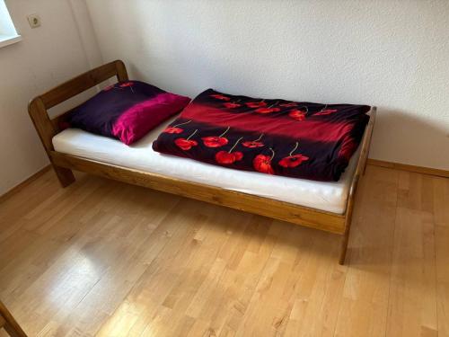 a bed with a red blanket on top of it at Ferienwohnung Hainspitz Longstay in Hainspitz