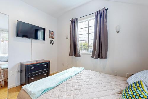 a bedroom with a bed and a tv on a wall at Rosie’s Retro River Flat in Portland