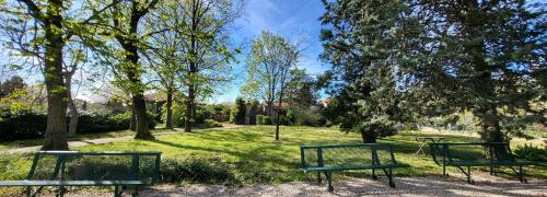 two green benches in a park with trees at Daisy Champêtre #Terrasse #Clim #Parking in Irigny