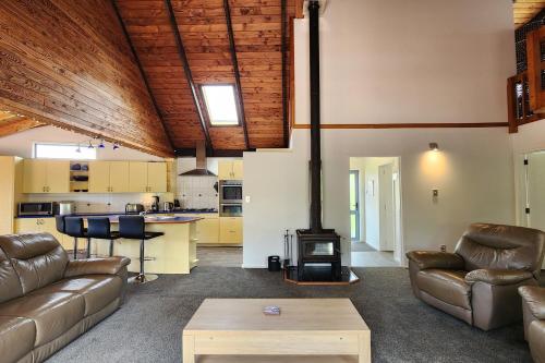 a living room with a couch and a stove at FlipFlop Inn Hahei Beach in Hahei