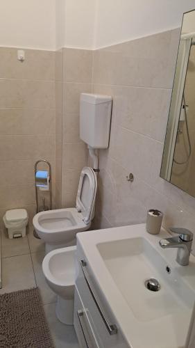 a white bathroom with a toilet and a sink at Valtellina Sondrio Holidays 3 in Sondrio