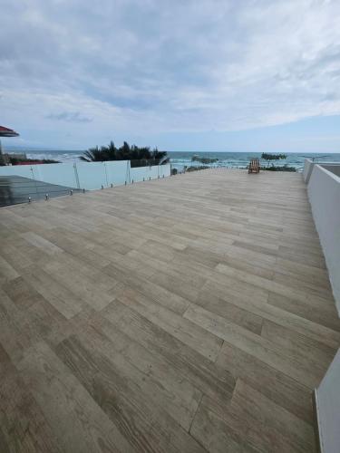 a large patio with the ocean in the background at Ola dorada de Canoa in El Recreo
