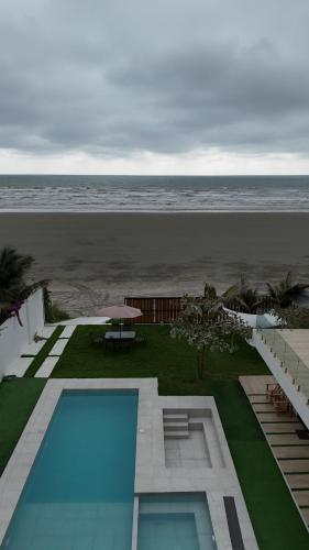 a view of a swimming pool and the beach at Ola dorada de Canoa in El Recreo