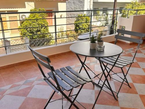 Un balcón con una mesa y sillas en un balcón. en The rabbits' house, en Nauplia