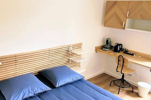 Cette petite chambre comprend un lit bleu et un bureau. dans l'établissement Studio cosy, rénové, bien situé, parking privé, à Grenoble