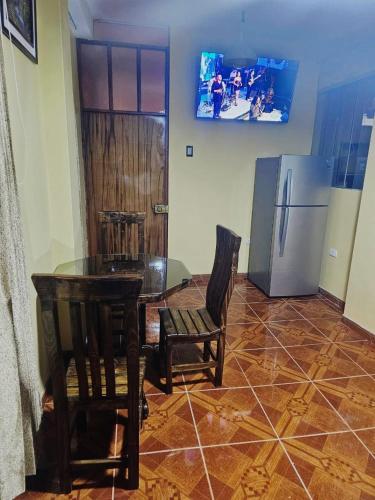 a dining room with a table and chairs and a refrigerator at La Casa de las 7 Esquinas in Puno