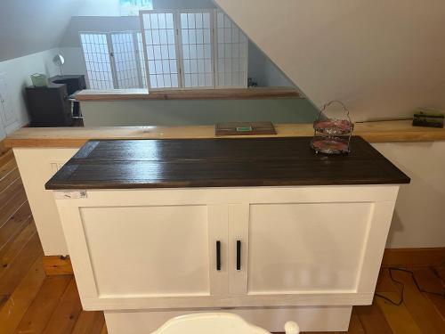 a white cabinet with a black counter top in a room at The Lakeview Loft in Port Colborne
