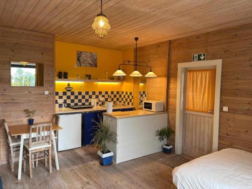 a kitchen with yellow walls and a bed in a room at Hanami - studio in Zwalm