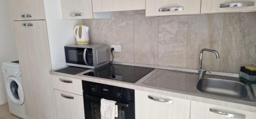 a kitchen with a microwave and a sink at PACEVILLE St Julians Apartments in St Julian's