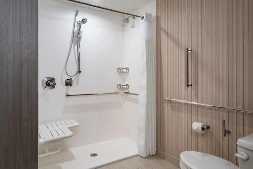 a white bathroom with a shower and a toilet at Courtyard by Marriott Port St. Lucie Tradition in Port Saint Lucie