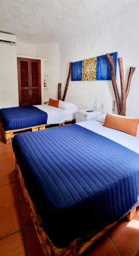 two beds in a hotel room with blue sheets at Mia Nueva Gorgona in Nueva Gorgona