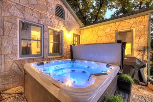 eine Whirlpool-Badewanne vor einem Steingebäude in der Unterkunft Ruth's Place - Walk to Main Hot Tub & Fire Pit in Fredericksburg