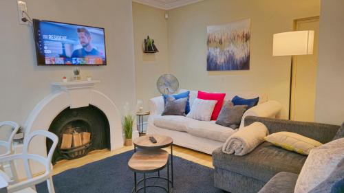a living room with a couch and a fireplace at Stylish 2 Bedroom Apartment, Leeds Centre + Free Parking in Leeds