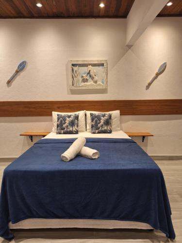 a bedroom with a bed with a blue blanket at Pousada Schueng in Trindade