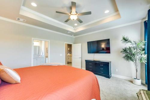 a bedroom with an orange bed and a ceiling fan at Texas Home with Hot Tub 3 Mi to Downtown Canyon! in Canyon