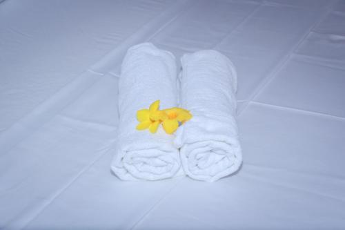a white towel with a yellow flower on it at Aloe Vera Garden in Tangalle