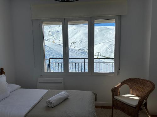 Un dormitorio con una cama, una silla y una ventana en Luxury Apartment Zona baja, en Sierra Nevada
