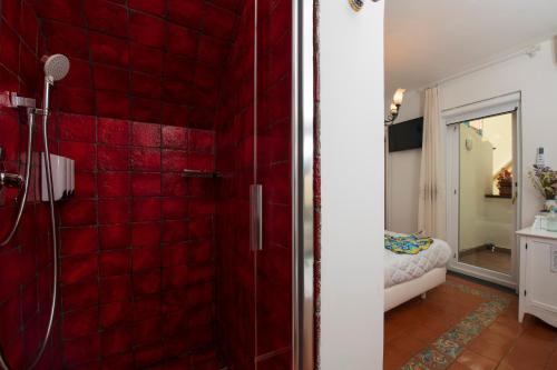 a red tiled bathroom with a shower with red tiles at ApartHotel Antica Repubblica in Amalfi center at 100mt from the sea in Amalfi
