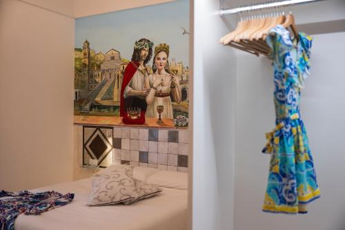 a bedroom with a painting of two people on the wall at ApartHotel Antica Repubblica in Amalfi center at 100mt from the sea in Amalfi